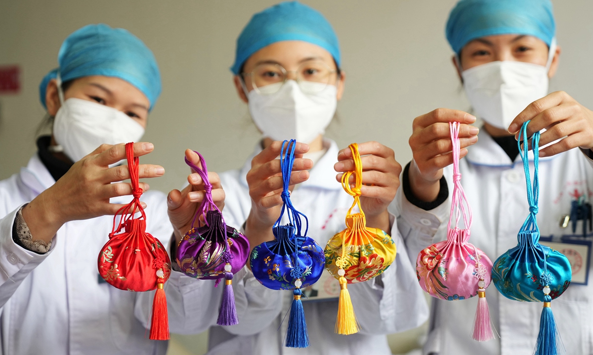 Medical staff from a hospital of traditional Chinese medicine in South China’s Guangxi Zhuang Autonomous Region display their sachet bags. Photo: VCG 